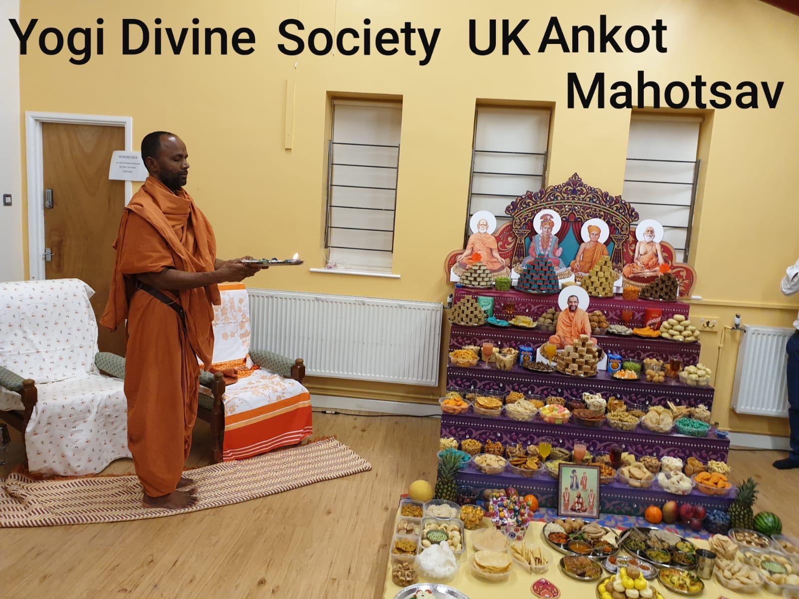 Sadhu performing arti before a tiered annakut offering at a Yogi Divine Society UK celebration